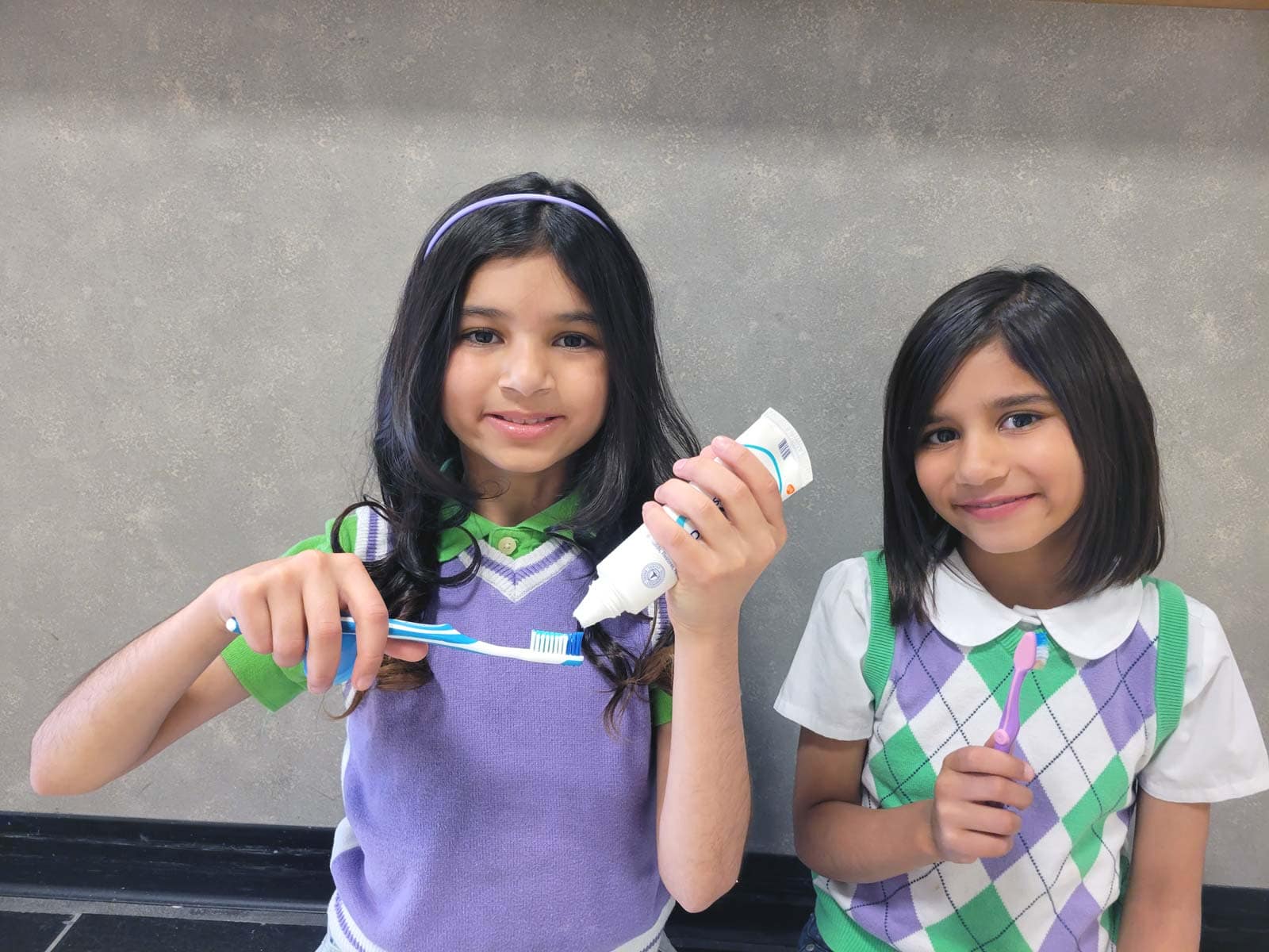Young girls holding toothbrushes