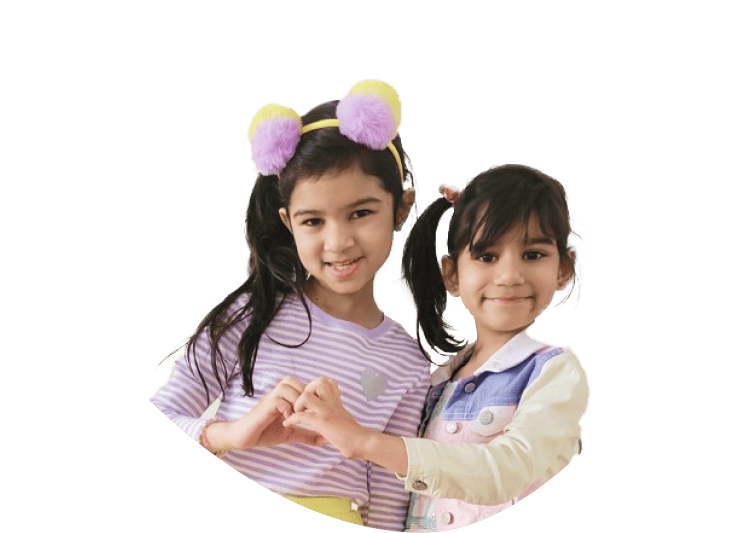 Two young girls smiling and forming a heart with their hands