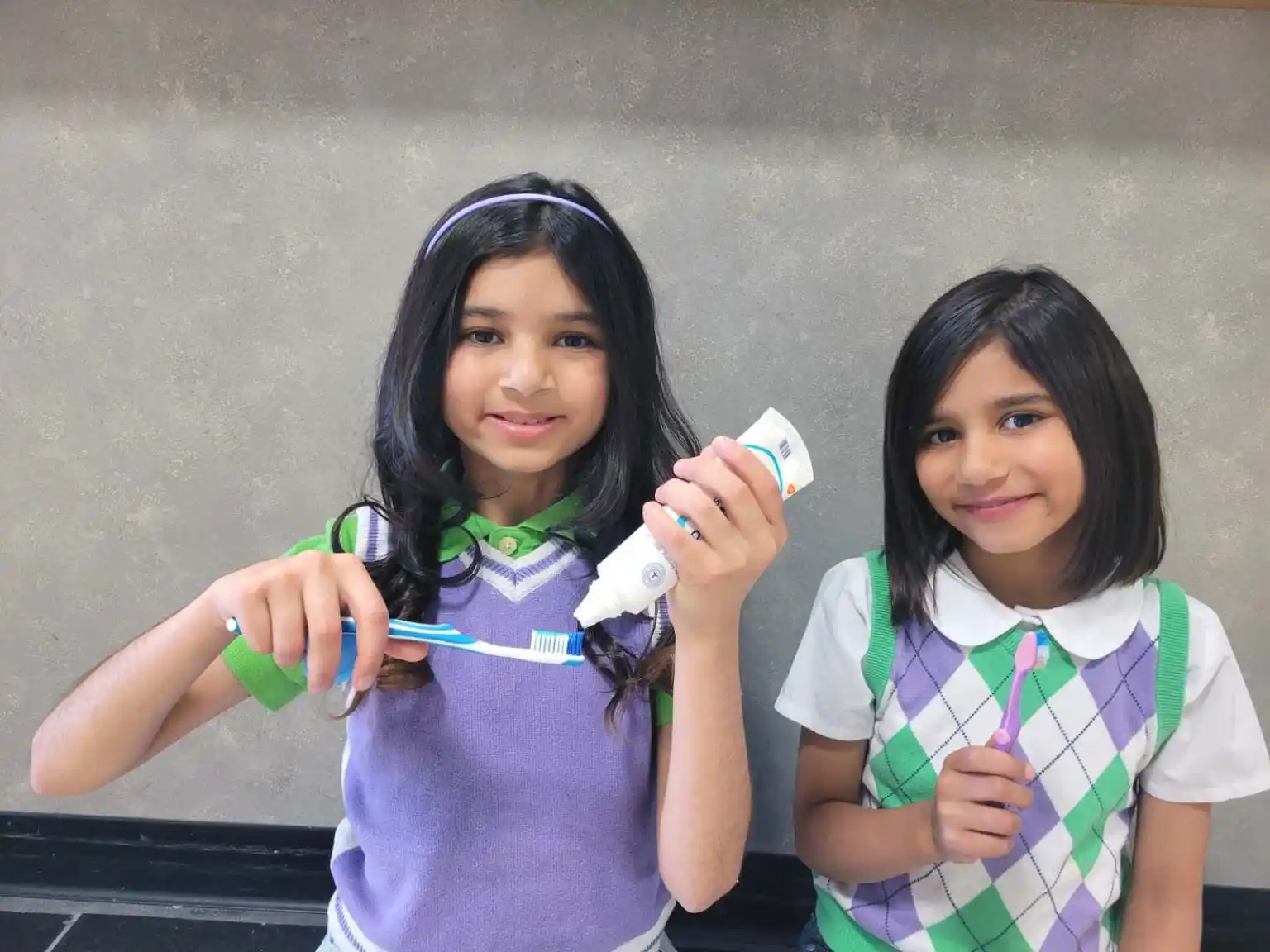 Young girls holding toothbrushes