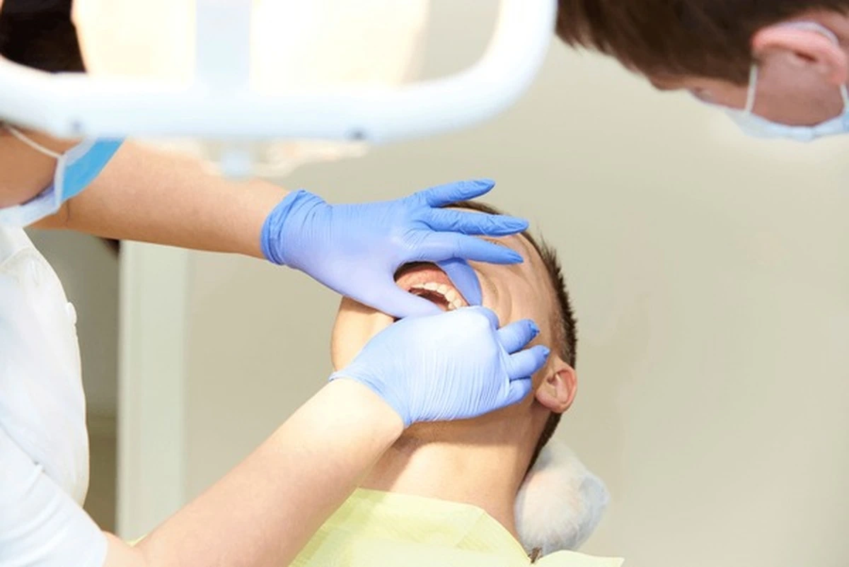 Pediatric pulpotomies Frisco TX: child with mouth prop in gentle pulp treatment at Dental Smart Kids