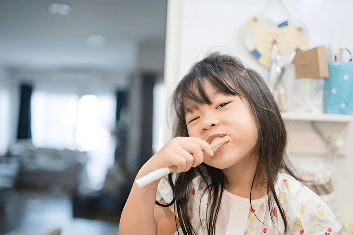 Curious kid exploring oral hygiene tools – complementing fluoride treatments for stronger teeth at Dental Smart Kids in Frisco, TX