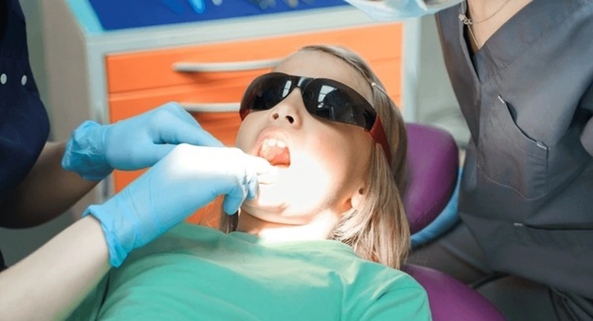"Oral cancer screening Frisco TX at Dental Smart Kids: young girl relaxed with sunglasses during gentle exam