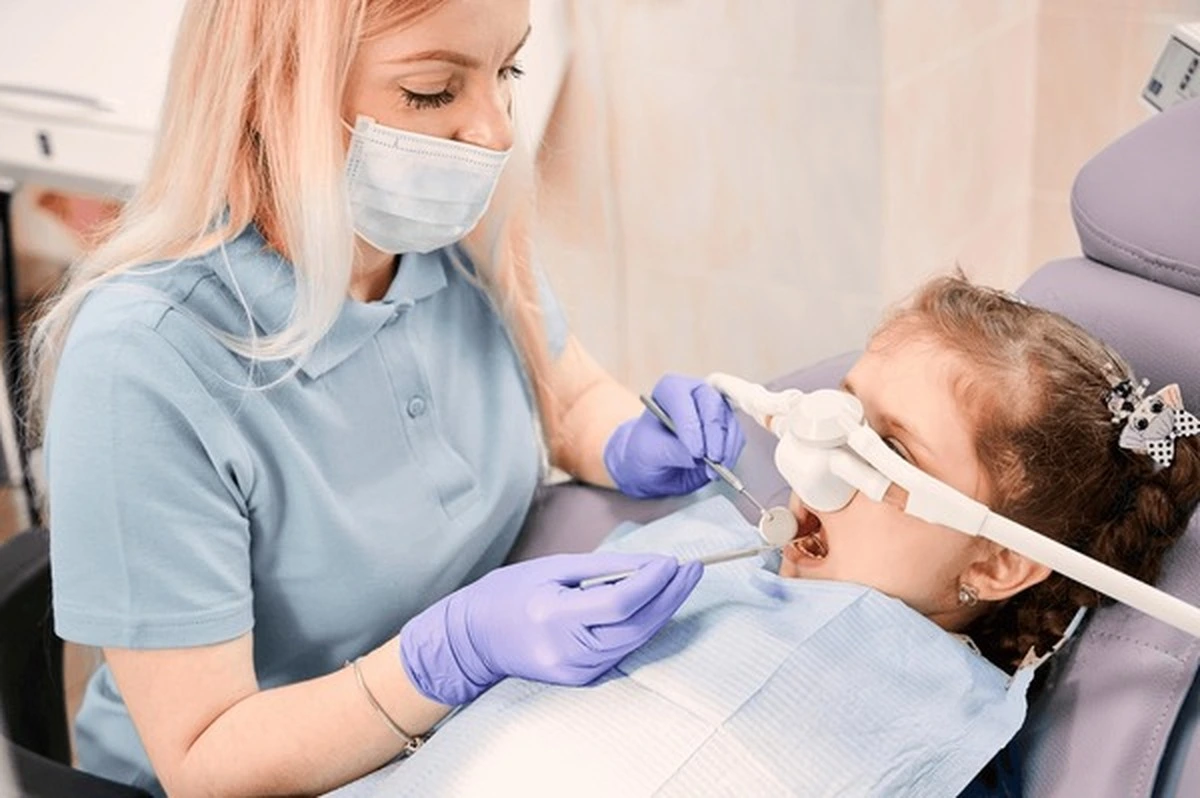 Pediatric sedation dentistry in Frisco TX with a gentle dentist helping a child relax using nitrous oxide at Dental Smart Kids